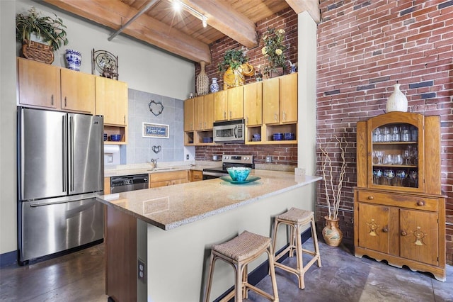 kitchen featuring beam ceiling, a kitchen bar, stainless steel appliances, and wooden ceiling