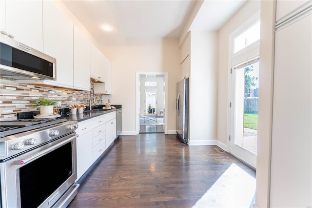 kitchen featuring appliances with stainless steel finishes, tasteful backsplash, dark hardwood / wood-style floors, and white cabinets