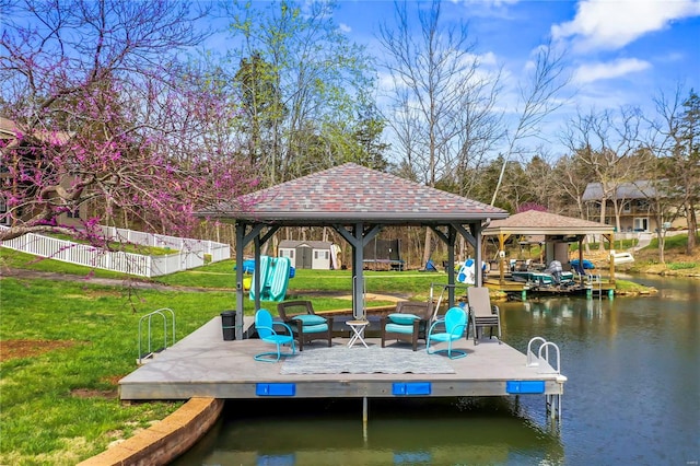 view of dock featuring a gazebo, a water view, and a yard