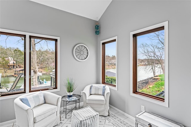 sitting room featuring a water view, light tile patterned flooring, and lofted ceiling