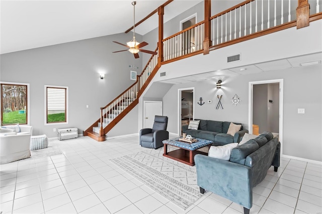 living room with ceiling fan, high vaulted ceiling, and light tile patterned flooring