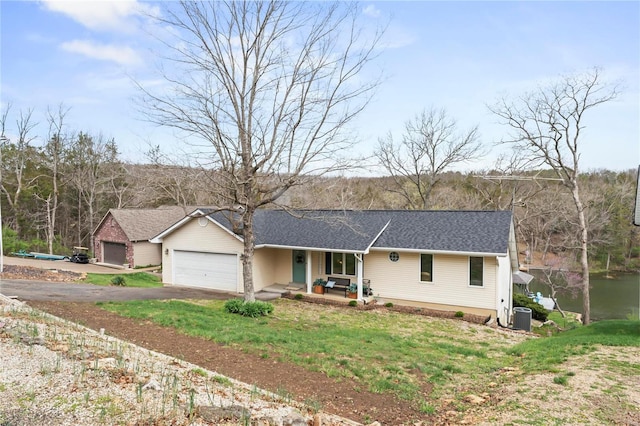 ranch-style home with a front lawn, covered porch, a garage, and cooling unit