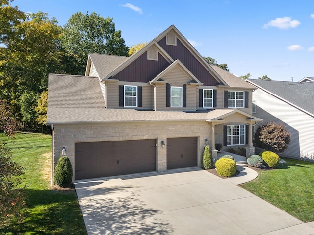 view of front facade with stone siding, driveway, a front yard, and a shingled roof