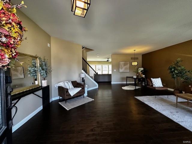 foyer featuring baseboards, wood finished floors, and stairs