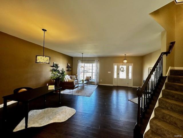 living area with stairs, wood finished floors, and baseboards