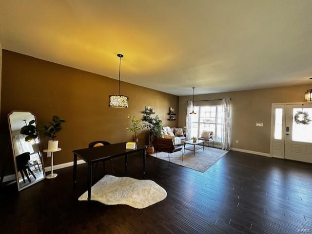 interior space with baseboards and wood finished floors