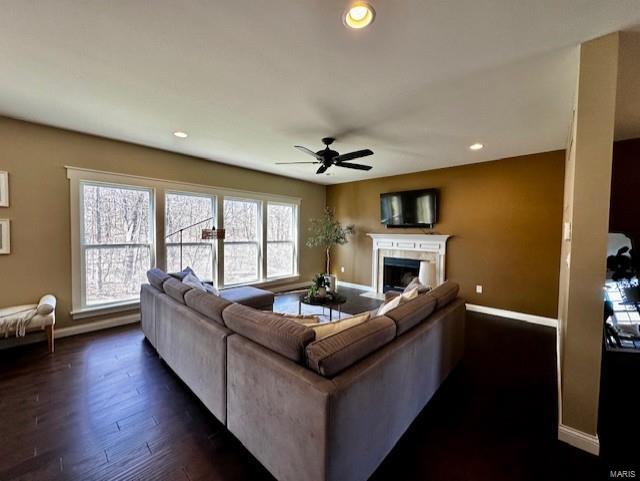 living room featuring dark wood-type flooring, recessed lighting, a fireplace, baseboards, and ceiling fan