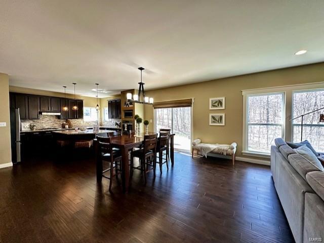 dining area with recessed lighting, baseboards, dark wood-type flooring, and a chandelier