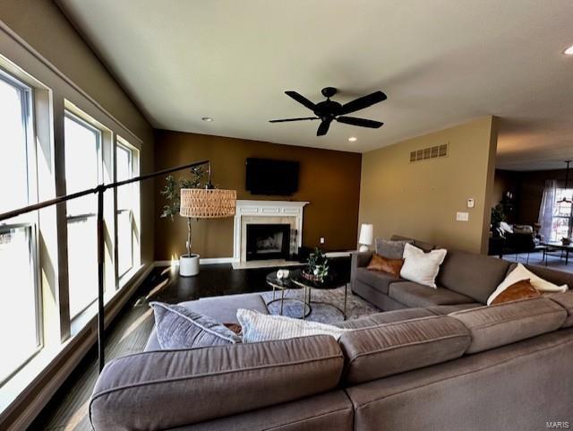 living room with a ceiling fan, wood finished floors, visible vents, recessed lighting, and a fireplace