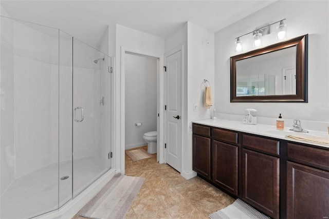 full bath featuring baseboards, vanity, toilet, and a shower stall