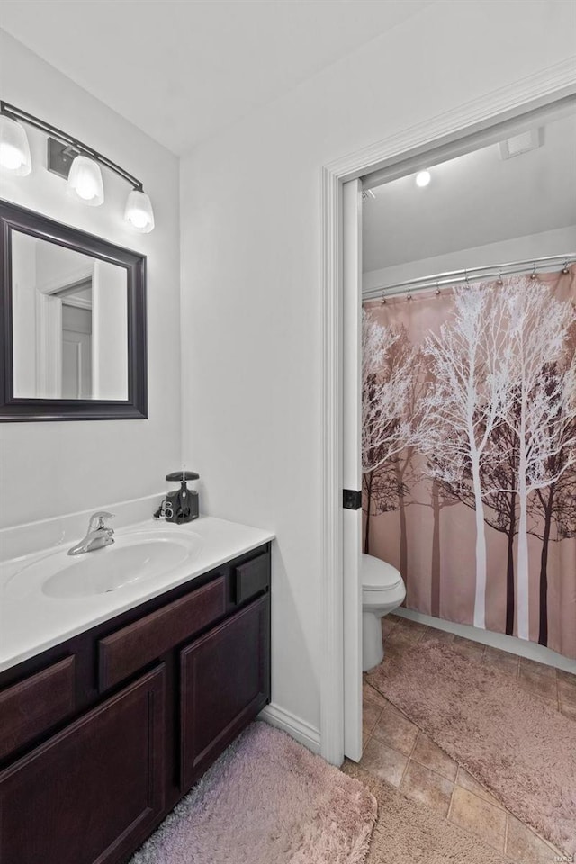 bathroom featuring vanity, toilet, and stone tile flooring