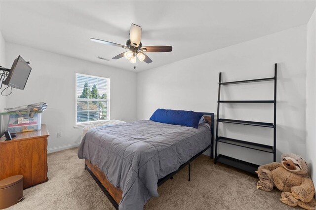 bedroom featuring visible vents, light colored carpet, a ceiling fan, and baseboards