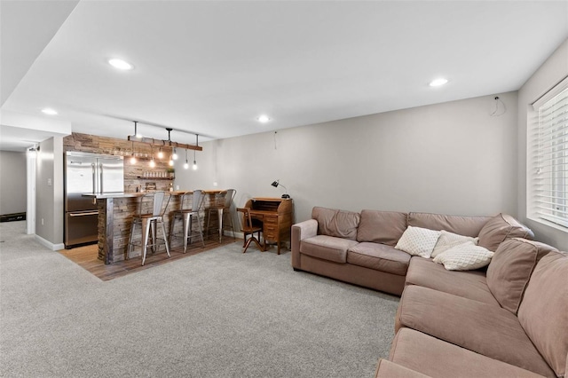 living area with bar, recessed lighting, baseboards, and light carpet