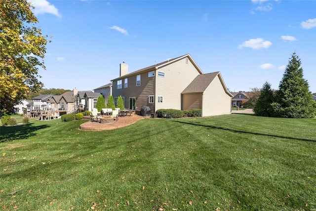 back of property with a residential view, a patio, a lawn, and a chimney