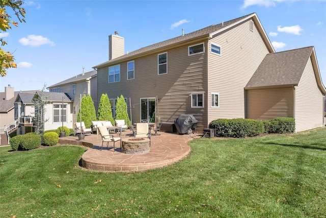 rear view of house featuring a fire pit, a patio, a lawn, and a chimney