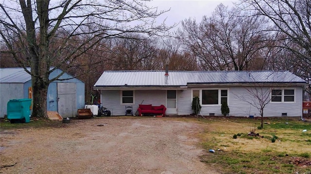 ranch-style house featuring metal roof, an outdoor structure, dirt driveway, crawl space, and a shed