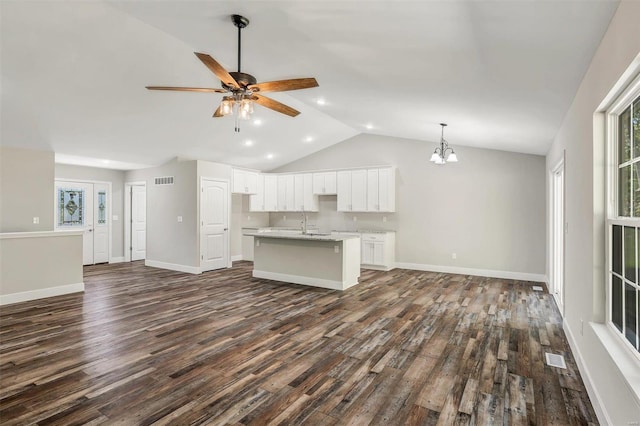 unfurnished living room with ceiling fan with notable chandelier, lofted ceiling, and dark wood-type flooring