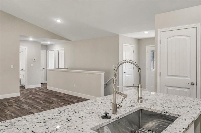 kitchen featuring light stone countertops, lofted ceiling, dark hardwood / wood-style floors, and sink