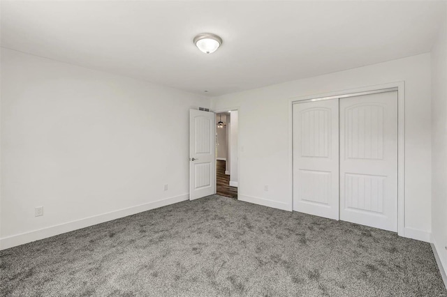 unfurnished bedroom with a closet and carpet flooring