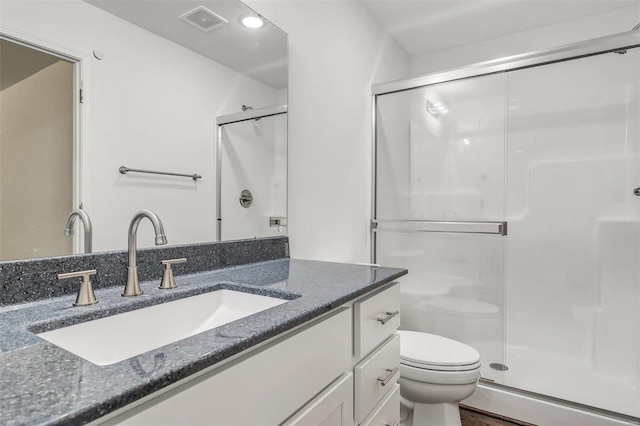 bathroom featuring vanity, toilet, a shower with door, and hardwood / wood-style flooring