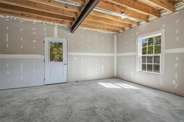 empty room with concrete floors and a wealth of natural light