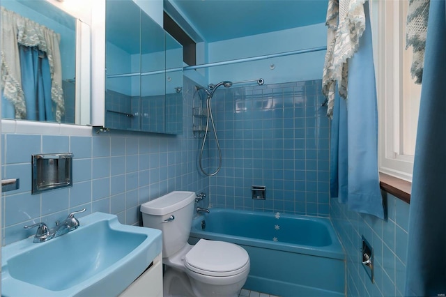 full bathroom with toilet, tile walls, decorative backsplash, tiled shower / bath, and vanity