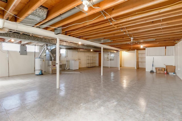 basement with water heater, heating unit, electric panel, and washer / dryer