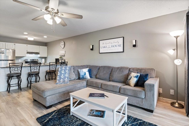 living room with ceiling fan and light wood-type flooring