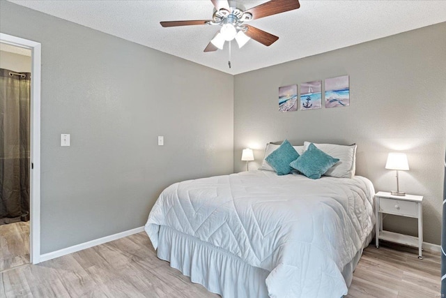 bedroom featuring ceiling fan, a textured ceiling, and light wood-type flooring