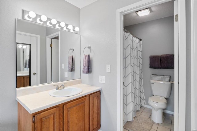 bathroom featuring toilet, vanity, a textured ceiling, and tile patterned floors