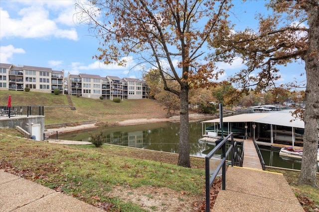 view of dock with a water view and a yard