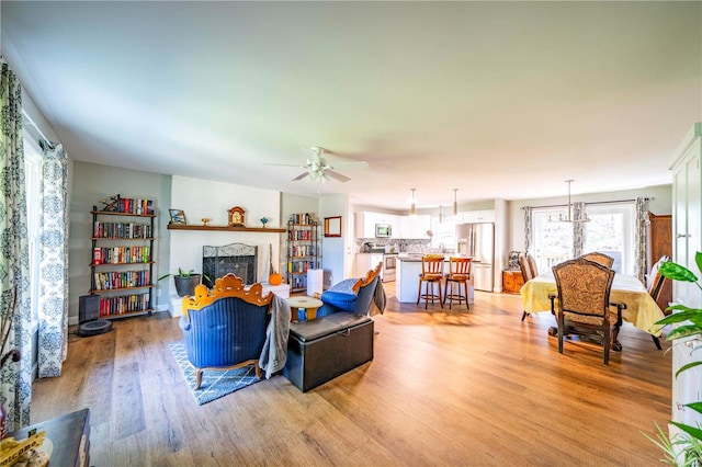 living room with light wood-type flooring and ceiling fan