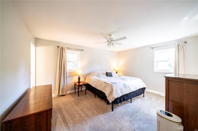 bedroom featuring light carpet, multiple windows, and ceiling fan