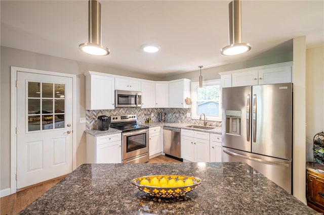 kitchen featuring pendant lighting, sink, stainless steel appliances, and white cabinets