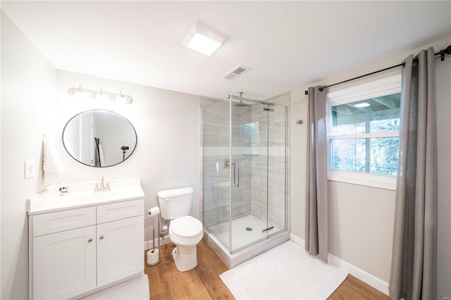 bathroom with an enclosed shower, hardwood / wood-style flooring, vanity, and toilet