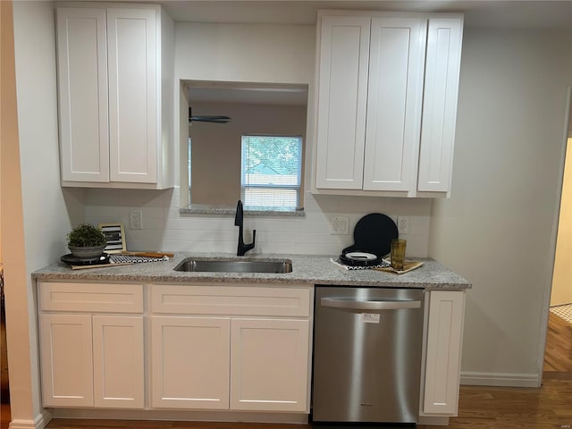 kitchen featuring hardwood / wood-style floors, dishwasher, white cabinetry, and sink