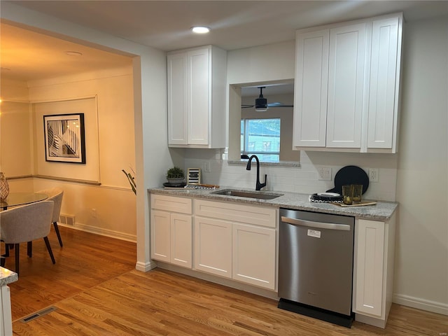 kitchen with light stone countertops, sink, stainless steel dishwasher, white cabinets, and light wood-type flooring