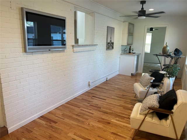 hall featuring brick wall and light hardwood / wood-style floors