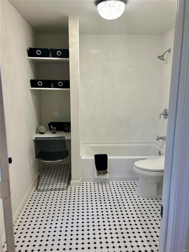 bathroom with tile patterned floors, tiled shower / bath combo, and toilet