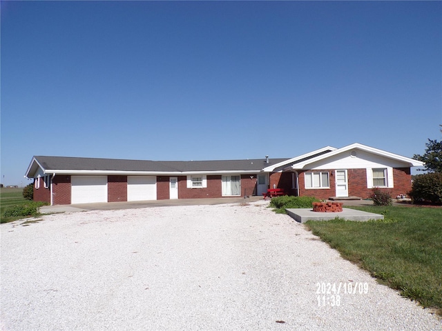 single story home featuring a garage and a front lawn