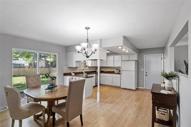 dining area featuring an inviting chandelier and light hardwood / wood-style floors