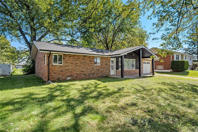 view of front of house featuring a garage, a front lawn, and brick siding