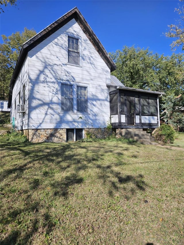 rear view of property featuring cooling unit, a sunroom, and a lawn