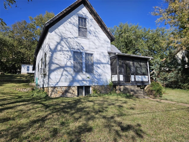 rear view of house with a sunroom and a lawn