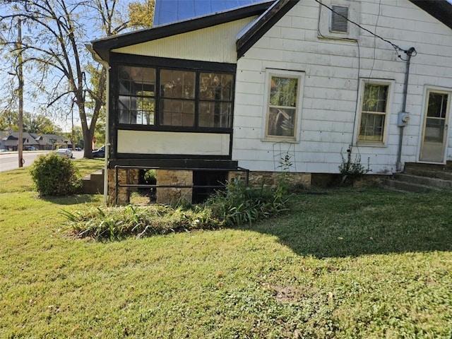 exterior space with a sunroom and a lawn