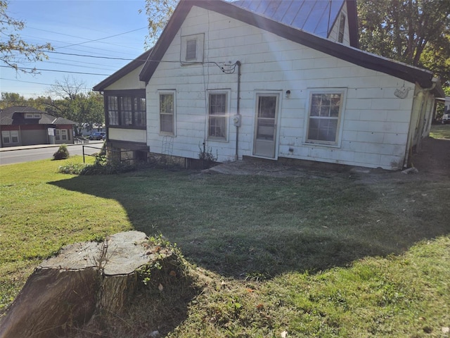 back of property featuring a lawn