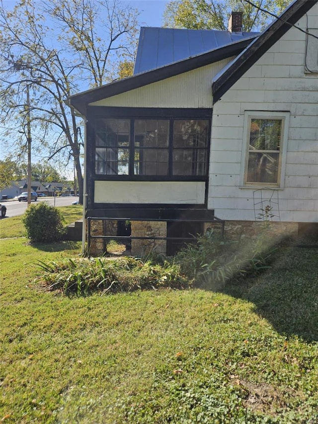 view of side of property featuring a yard and a sunroom