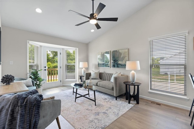 living room featuring high vaulted ceiling, ceiling fan, and light hardwood / wood-style floors