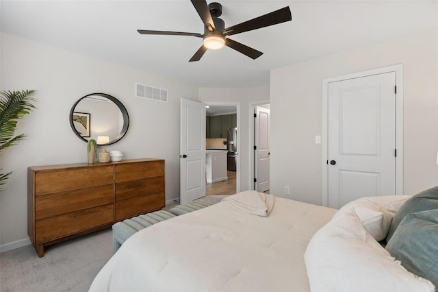 bedroom with ceiling fan, light colored carpet, a closet, and stainless steel fridge