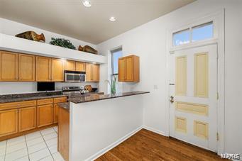 kitchen featuring kitchen peninsula, appliances with stainless steel finishes, and light hardwood / wood-style flooring